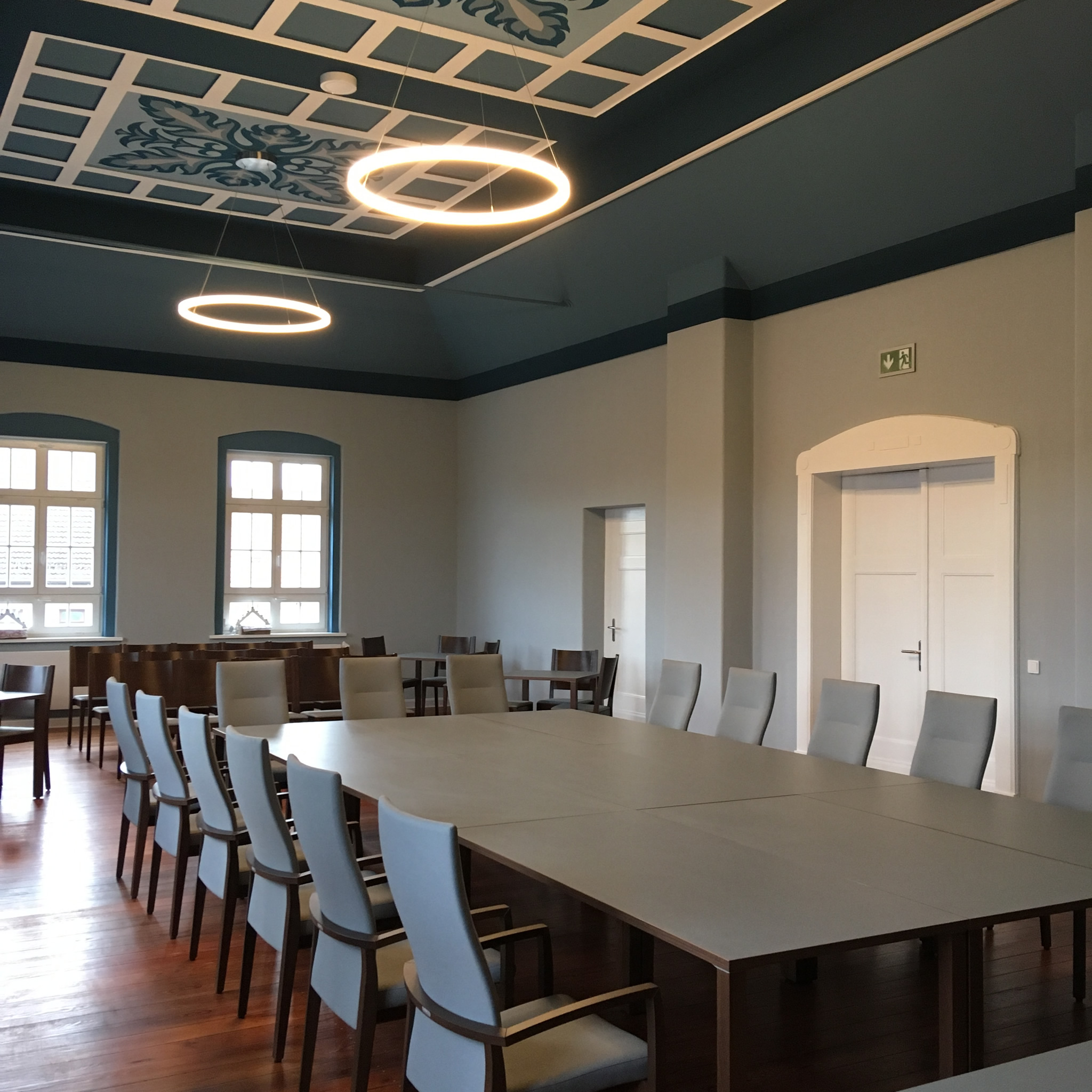 Große Designer-Ringleuchte über einem Konferenztisch